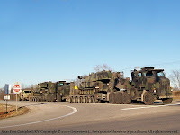Tanks on military transport trucks