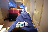 a person lying on a plane with a device on their lap