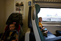 a baby sitting in a seat on a train