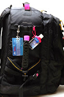 a black backpack with a pink and blue tag