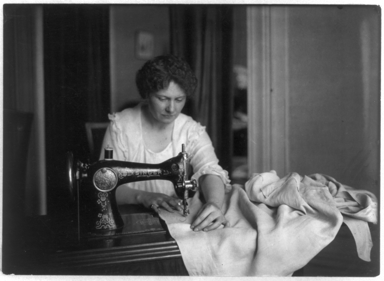 [Woman_sewing_with_a_Singer_sewing_machine.png]