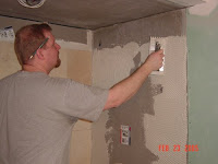 picture of man tiling shower