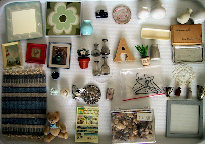 A selection of modern dolls' house miniature accessories, arranged neatly.