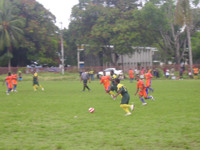 Eku player with the ball whilst being closely watched by Santos Mark