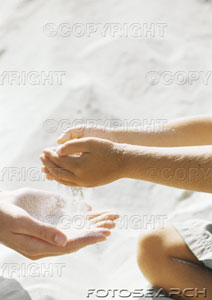 [child-letting-sand-run-through-cupped-hands-into-mothers-hands-~-paa278000021.jpg]