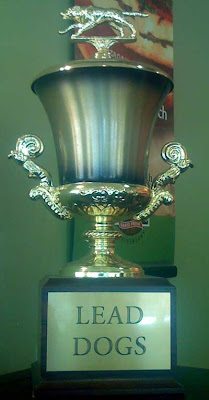 Photo of a trophy with a running dog at the top and the words Lead Dogs