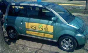 A green Zenn car with Linden Hills Co-op logo on the door