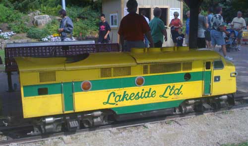Miniature locomotive the Lakeside Ltd adorned in green and yellow paint