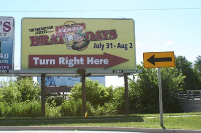 Billboard that reads Brat Days, with a big arrow pointing right. Next to it, a yellow road sign with a big black arrow pointing left