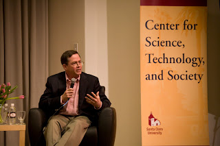 Jim Fruchterman seated next to sign for SCU's Center for Science Tech & Society