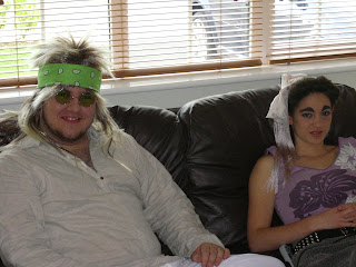 Two oddly dressed people on a sofa.