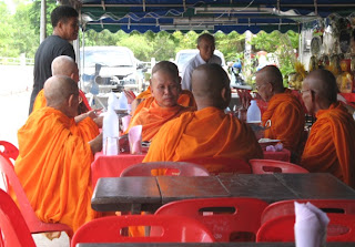 Family members serve food to the Monks