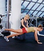 two women, one doing a plank exercise with leg in the air, the other one spotting her
