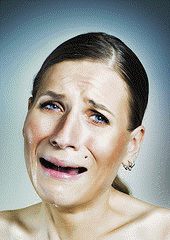 picture of brown-haired woman with her hair pulled back in a pony tail, crying